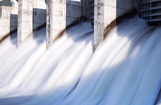 Water in long exposure rushing out of open gates of a hydro electric power station