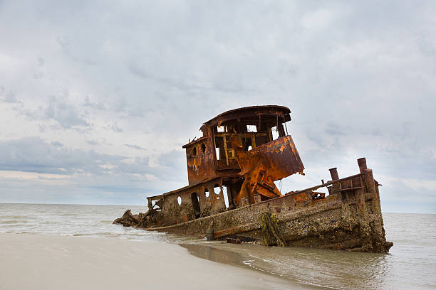 Wrecked Tug Boat A wrecked tug boat on the shore of Little St. Simons Island, Georgia.  The rusted hull of a tub boat that was separated from it's ship in heavy seas and wrecked.  It was considered to costly to recover it so it has been left to slowly disintegrate. saint simons island photos stock pictures, royalty-free photos & images