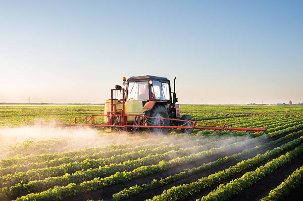 tractor en el campo de soja pulverización - maquinaria agrícola fotografías e imágenes de stock