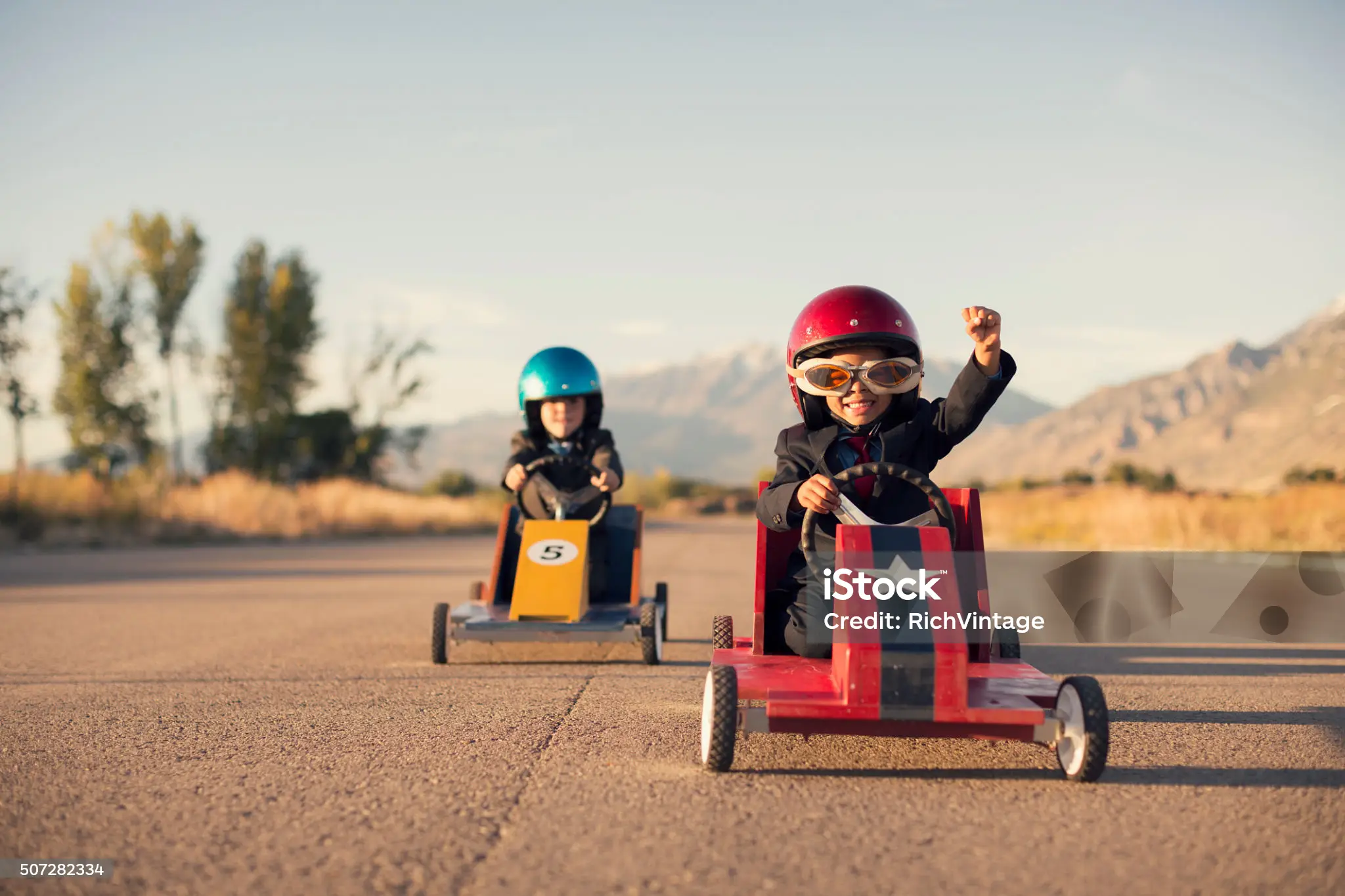 Junge Business-Jungen in Anzügen Rennen Spielzeug-Autos Lizenzfreies stock-foto