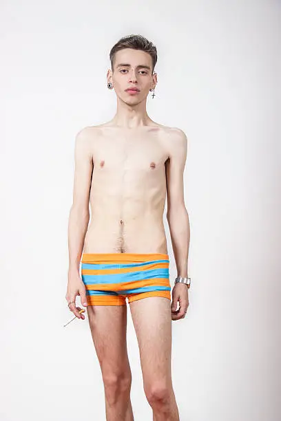 Young man with anorexia nervosa problem. White background.