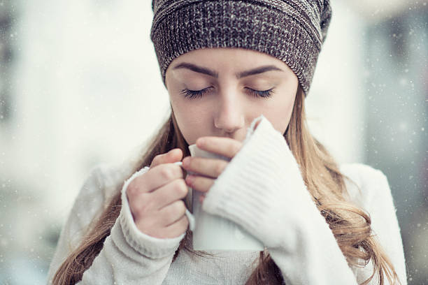 graziosa ragazza biondo bere tè caldo durante l'inverno neve - snow heat adult blond hair foto e immagini stock
