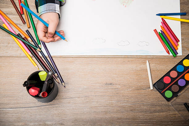 Child drawing on a white paper