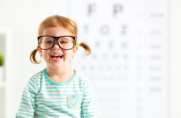 pojęcie wizji badania. dziecko dziewczynka z okulary - krótkowzroczność zdjęcia i obrazy z banku zdjęć