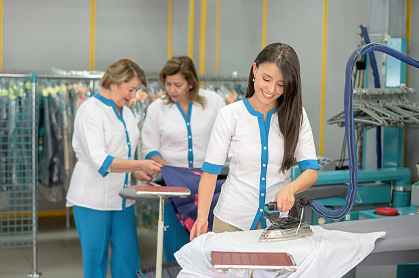 istock Women ironing clothes at a laundry shop 507298132