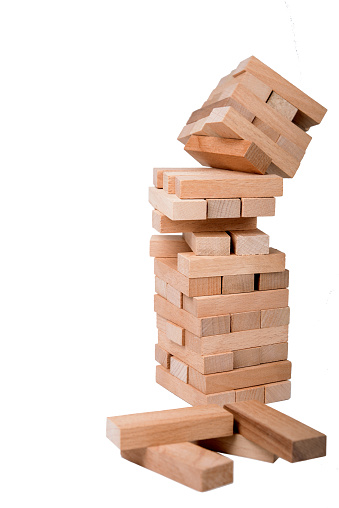Falling Wooden Block Tower On A White Background.