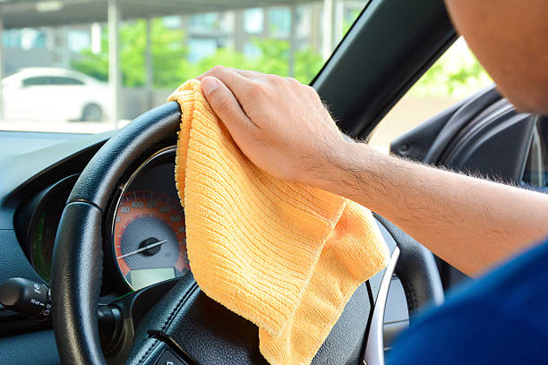 istock Man cleaning car steering wheel with microfiber cloth 507304024