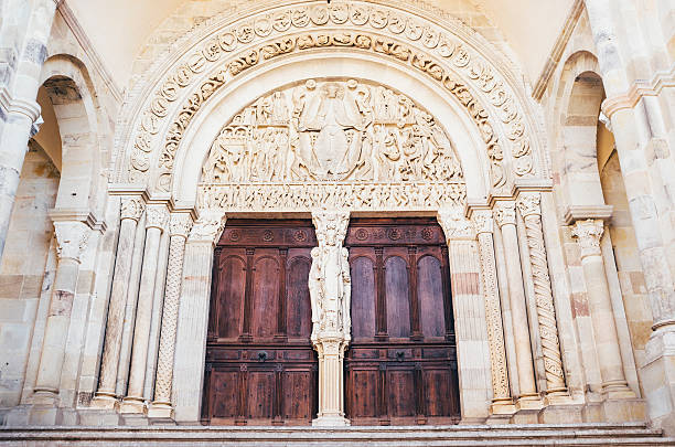 The Last Judgement sculpture by Gislebertus in the west tympanum at the Cathedrale Saint-Lazare d'Autun in Autun, Burgundy, France. Gislebertus created it around 1130AD, depicting the rise of heavenly paradise on the left and the fall to demonic hell on the right. It would give passing pilgrims a stern reminder of the fate awaiting them should they stray from the holy path.