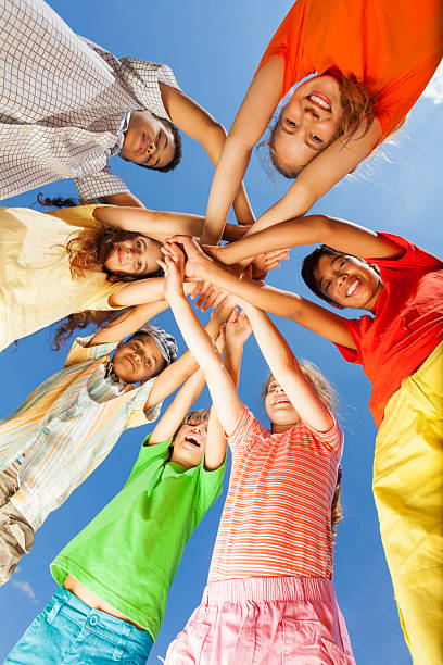 istock Kids put arms in star shape on sky background 507313327