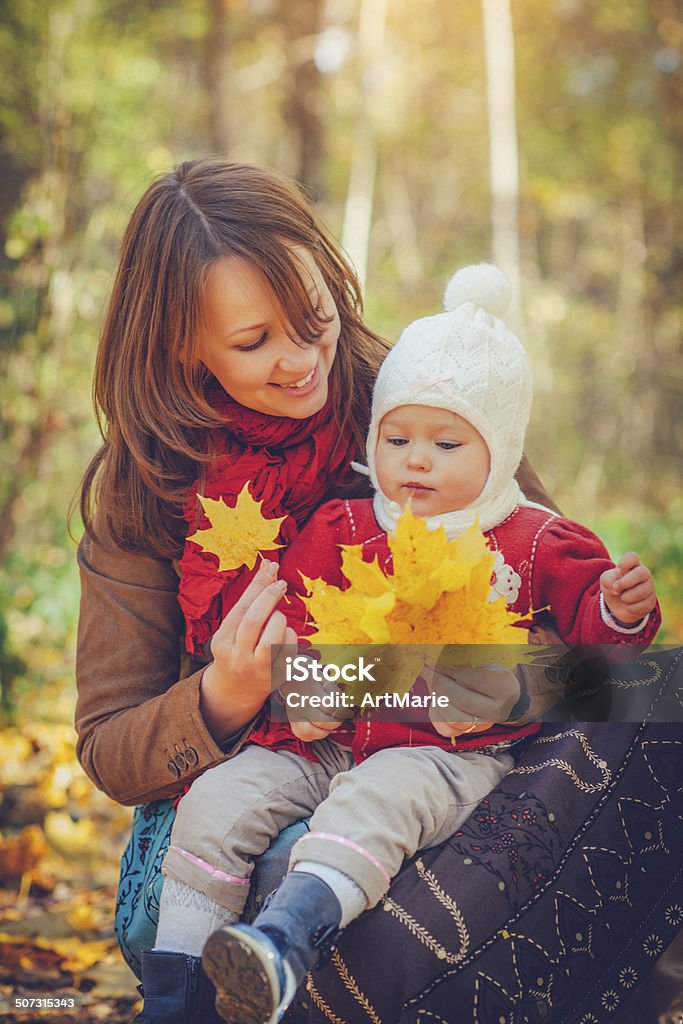 Family in autumn park Young mother with her daughter outdoors in autumn park Activity Stock Photo