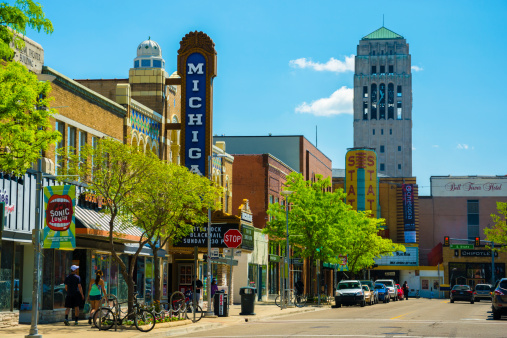 Ann Arbor, United States - May 25, 2014: Scene from Downtown Ann Arbor, Michigan, with shops, pedestrians walking, a theater, and a bell tower from the University of Michigan being shown.