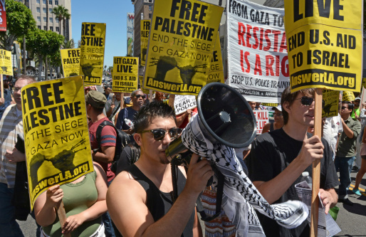 Hollywood, CA, USA - August 16, 2014: Surrounded by protest signs and banners, a Palestinian activist speaks into a bullhorn, leading a march on Hollywood Boulevard in protest Israeli military action in Gaza on August 16, 2014 in Hollywood, California.