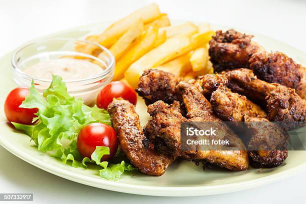 Alitas De Pollo Con Salsa Picante Papas Fritas Y Francesa Foto de stock y más banco de imágenes de Ala de animal