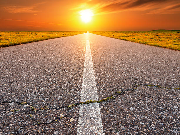 istock Driving on an empty asphalt road towards the sun 507334555