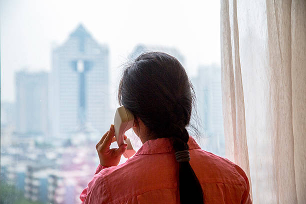istock girl making telephone beside window 507362964