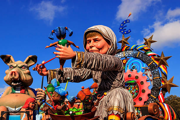 Putignano Carnival: floats. European politician: Angela Merkel torture Europe.ITALY(Apulia) Putignano,Apulia,Italy - February 15, 2015: carnival floats, giant paper mache. Float representative Angela Merkel. political joke stock pictures, royalty-free photos & images