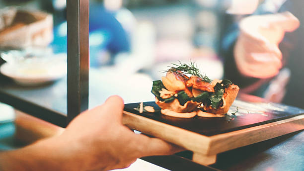 istock Waiter picking up a meal from serving hatch. 507363980