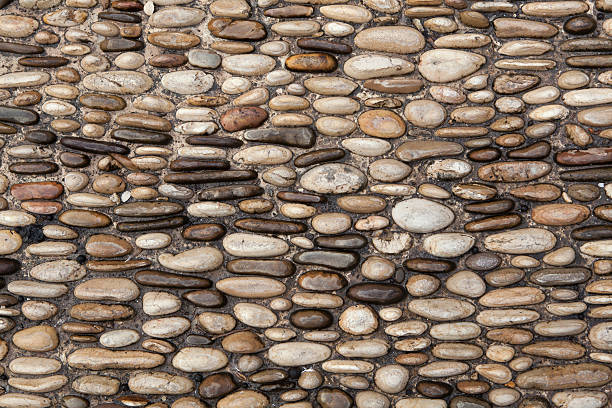 istock Cobbled pavement made of river rounded pebbles. Background textu 507365428