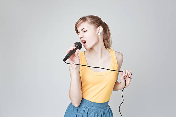 mujer cantar con el micrófono - singer singing women microphone fotografías e imágenes de stock