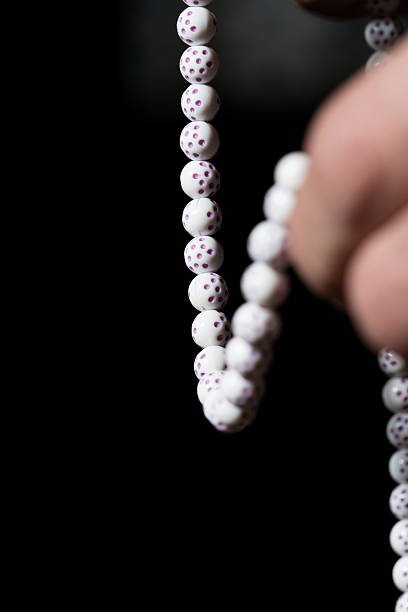 Close-Up Of Young Muslim Man With prayer beads Praying In Mosque