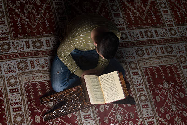 istock Arabic Muslim Man Reading Holy Islamic Book Koran 507371195