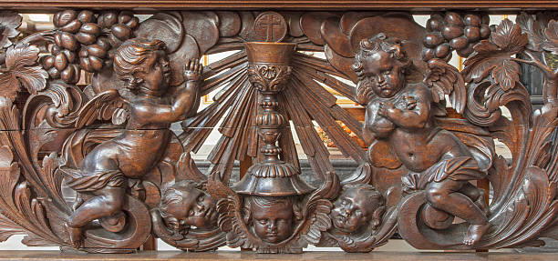 Bruges - Carved relief of angel and cup as the symbol of eucharist in Karmelietenkerk (Carmelites church) by carmelite Victor van de Heilige Jacob from 17. cent.