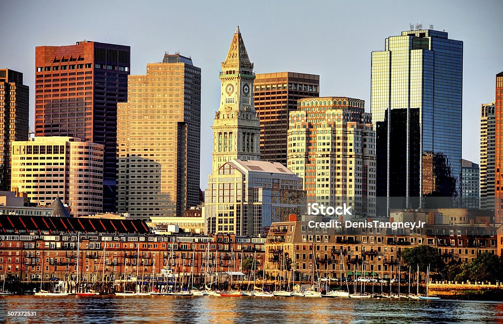 Boston Skyline Boston skyline including the Custom House Tower as seen from across the Boston Harbor. Boston is the largest city in New England, the capital of the state of Massachusetts. Boston is known for its central role in American history,world-class educational institutions, cultural facilities, and champion sports franchises. Architecture Stock Photo