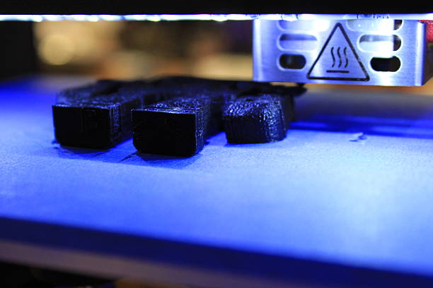 Object being 3D printed Macro of undetermined black object on blue printbed during the 3D printing process polylactic acid stock pictures, royalty-free photos & images