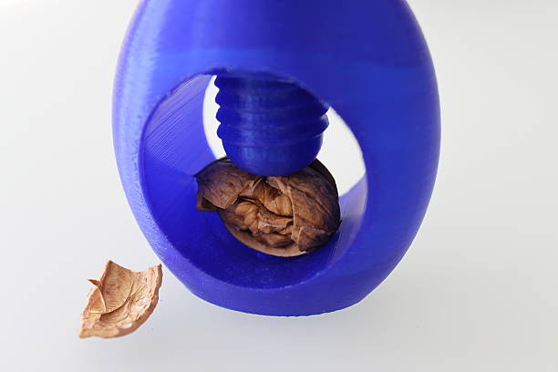3D printed nutcracker with cracked nut Macro of 3D printed blue nutcracker with cracked nut, full frontal view polylactic acid stock pictures, royalty-free photos & images