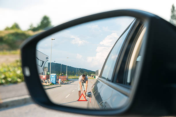 homem colocando o triângulo de aviso - multiple lane highway imagens e fotografias de stock