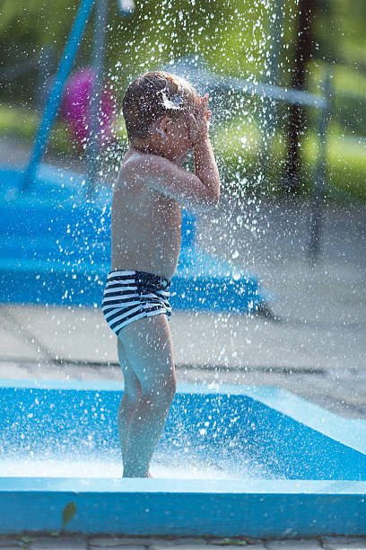 ragazzino nel parco acquatico - wading child water sport clothing foto e immagini stock