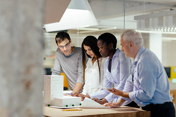 istock Multiethnic Team of architects reviewing architectural model in the office. 507375085