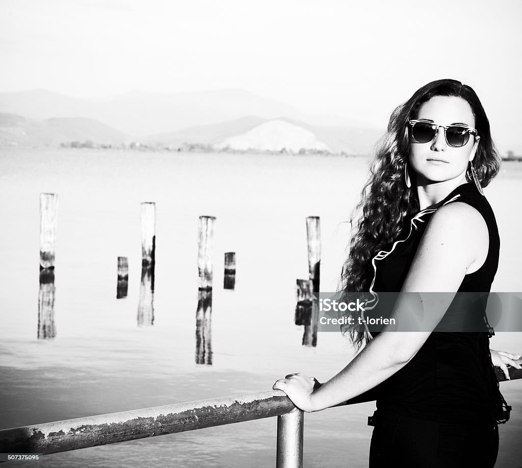 Young woman by lake . Beautiful young woman standing by lake in Italy. Lago di Massaciucoli. 20-29 Years Stock Photo
