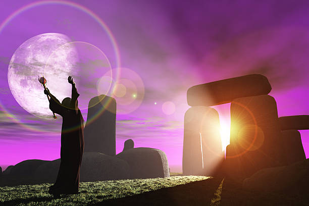 Druid greets the dawn at Stonehenge Fantasy render of Celtic druid bathing in sunrays shining through standing stones at Stonehenge merlin the wizard stock pictures, royalty-free photos & images