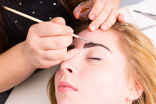 istock Esthetician Grooming Eyebrows of Female Client 507375528