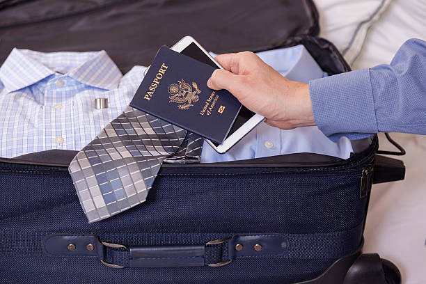 istock Businessman holds passport and cell phone in hotel room. Luggage. 507376077