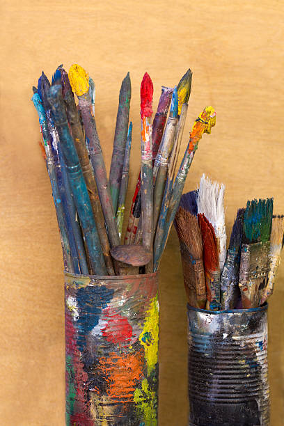 istock Artist's Colorful, Dirty Paintbrushes in Tin Cans 507376147