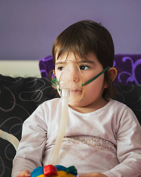 chica de la inhalación con mascarilla en la cara - tubing child oxygen mask medical oxygen equipment fotografías e imágenes de stock