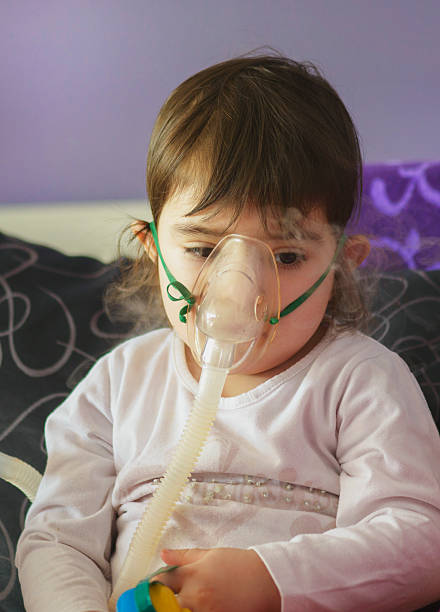 chica de la inhalación con mascarilla en la cara - tubing child oxygen mask medical oxygen equipment fotografías e imágenes de stock