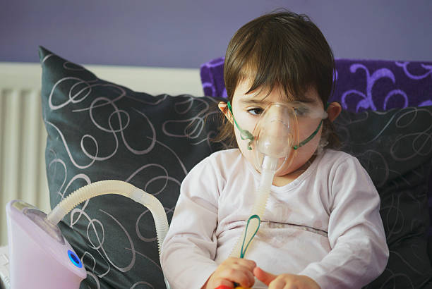 chica de la inhalación con mascarilla en la cara - tubing child oxygen mask medical oxygen equipment fotografías e imágenes de stock