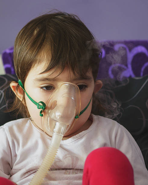 chica de la inhalación con mascarilla en la cara - tubing child oxygen mask medical oxygen equipment fotografías e imágenes de stock