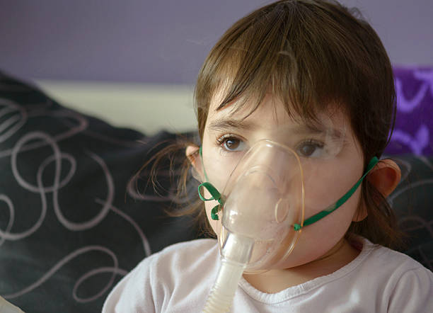 chica de la inhalación con mascarilla en la cara - tubing child oxygen mask medical oxygen equipment fotografías e imágenes de stock