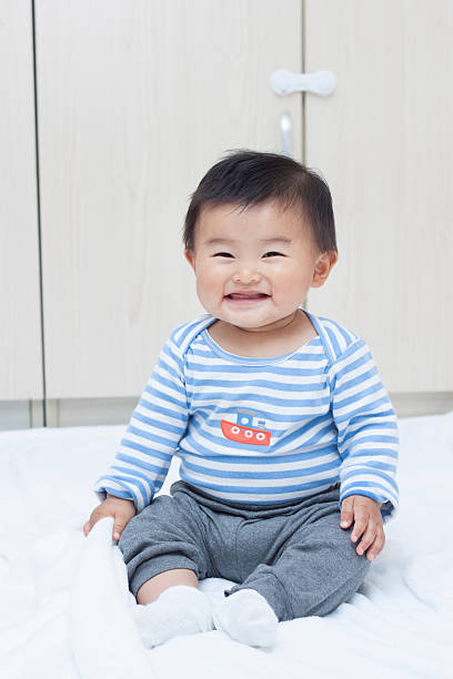 istock Cute Chinese baby boy sitting on a white blanket 507377588