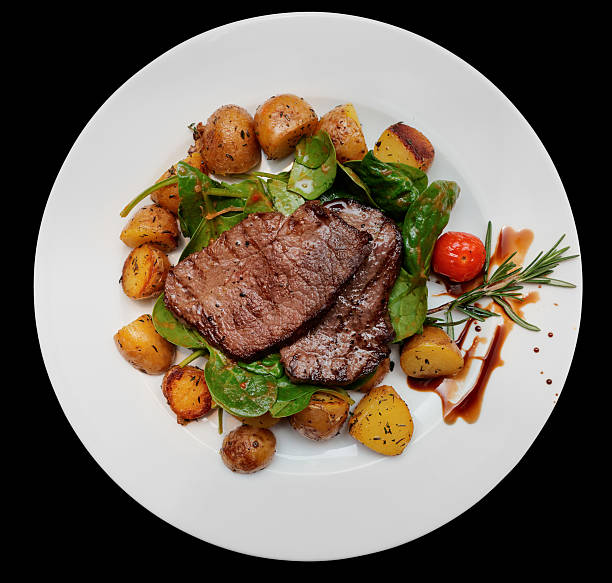 Steak with fried potatoes on wooden table Steak with fried potatoes and spinach on wooden table big plate of food stock pictures, royalty-free photos & images