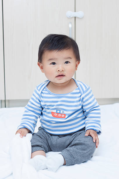 istock Cute Chinese baby boy sitting on a white blanket 507377686