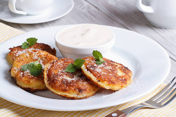 istock Portion cheese pancakes on a white plate with sour cream 507395165