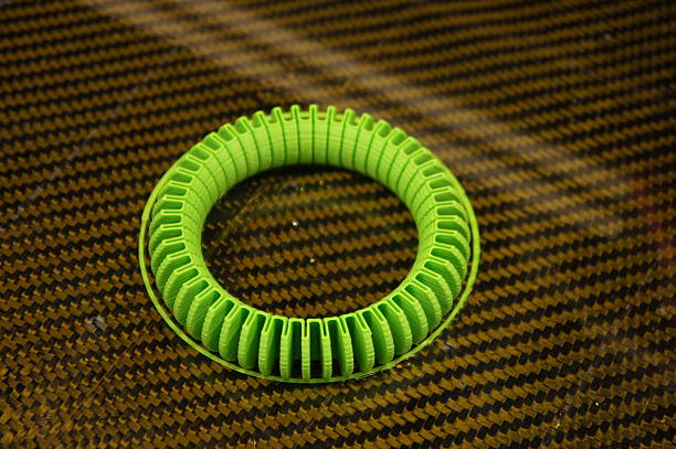 3D printed flexible bracelet Green 3D printed flexible bracelet on carbon-fibre printbed polylactic acid stock pictures, royalty-free photos & images