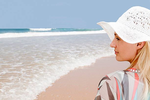 istock Rear view on woman at beach with white sun hat. 507396390