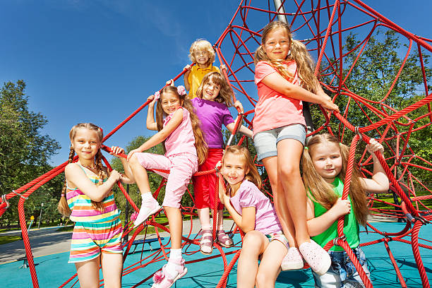 istock Smiling group of children sit on red ropes 507396413