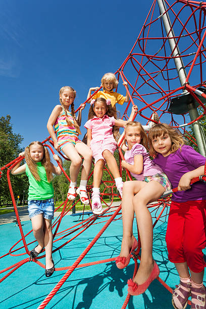 istock Many kids sit on red ropes of playground 507396415
